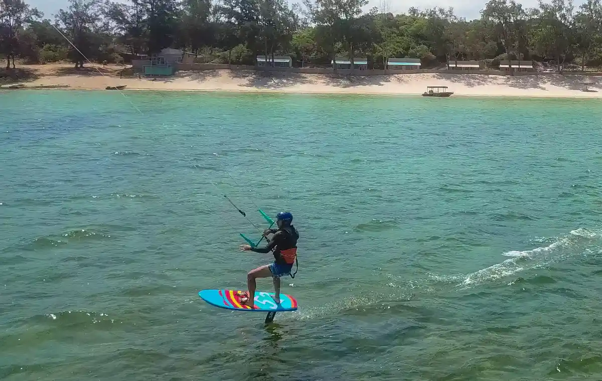 Rider en kitefoil glissant sur les eaux turquoise de la lagune de Bilene