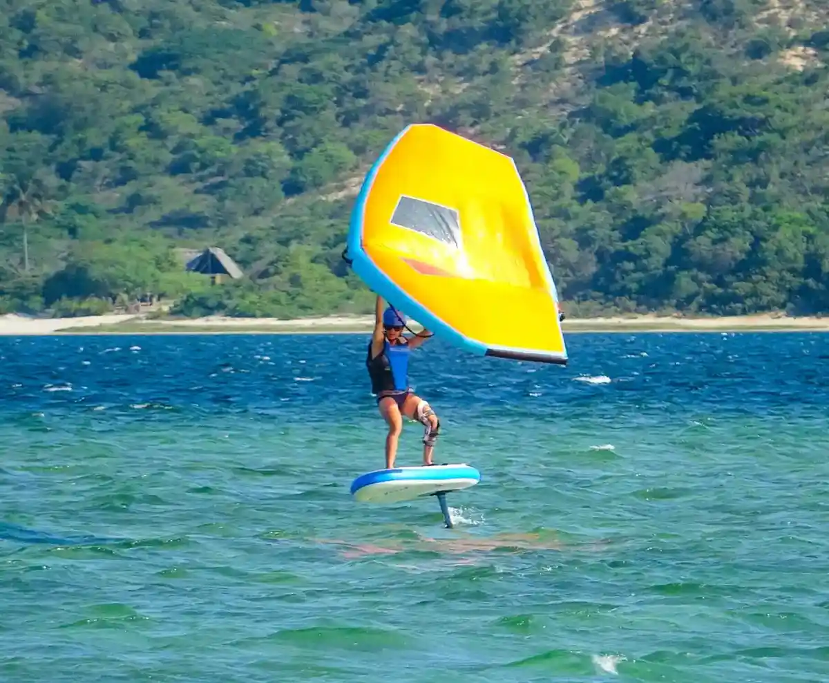 Rideuse en wing foil sur la lagune de Bilene, aile jaune déployée
